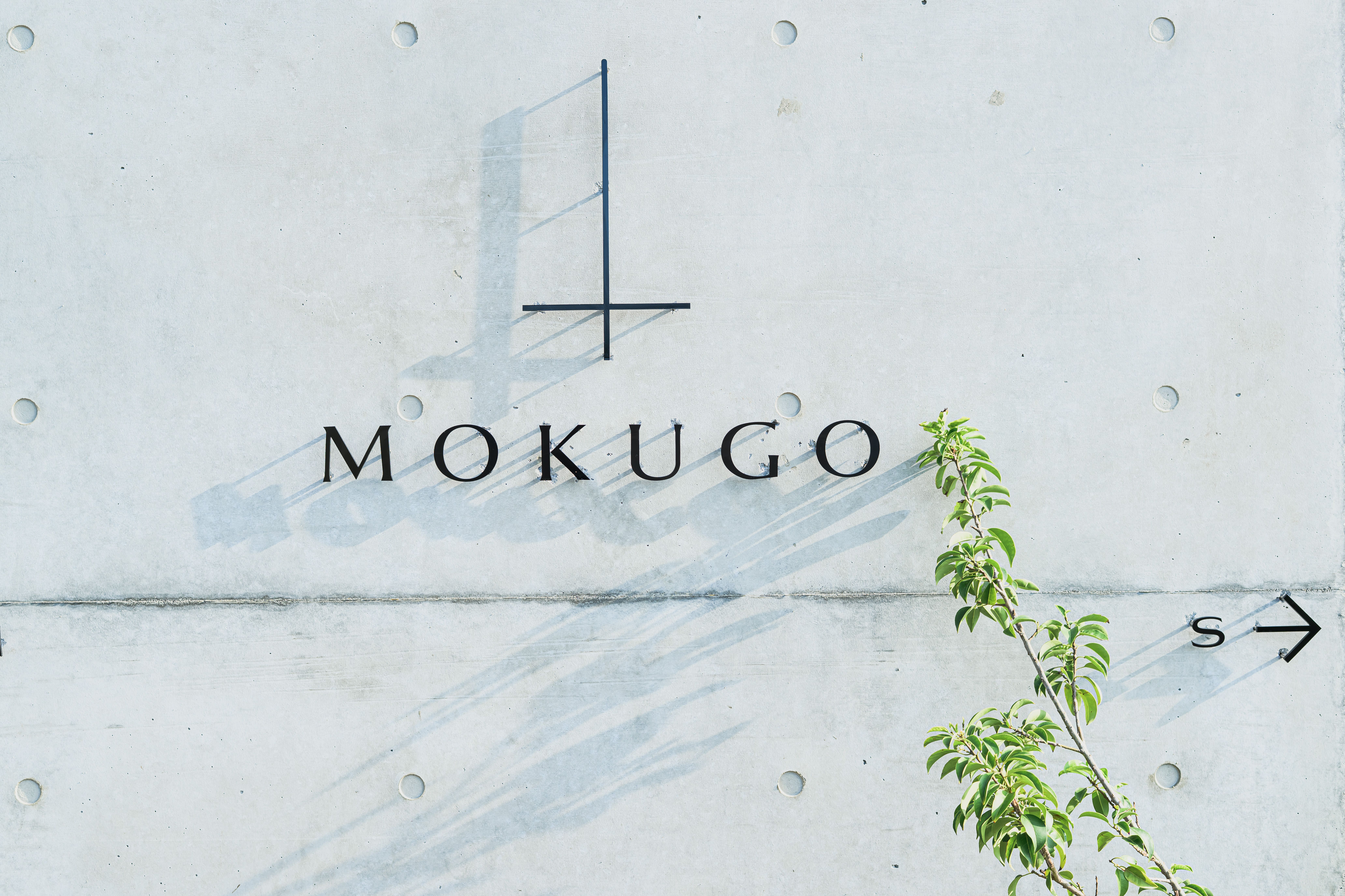 MOKUGOのサインに刻まれた棟への案内矢印