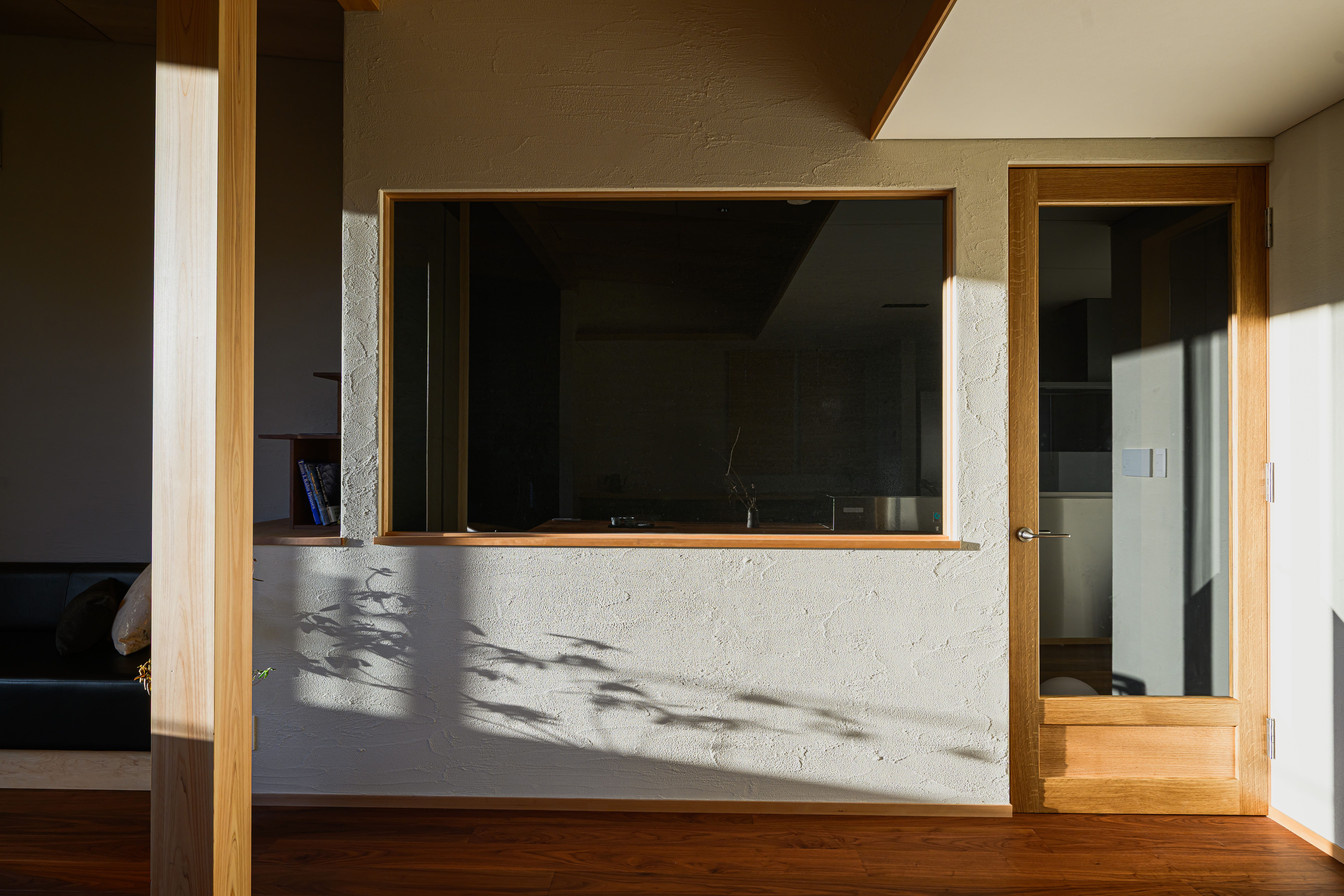 木の枠、壁の陰影、室内アートが重なる North Wing の一角